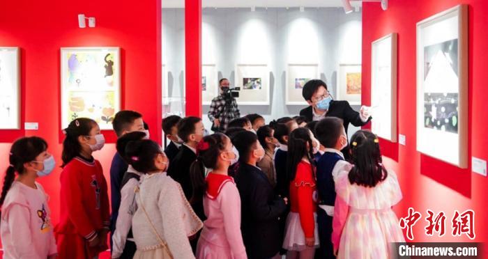 图为在展场中参观插画作品的小学生们。上海宝山国际民间艺术博览馆 供图